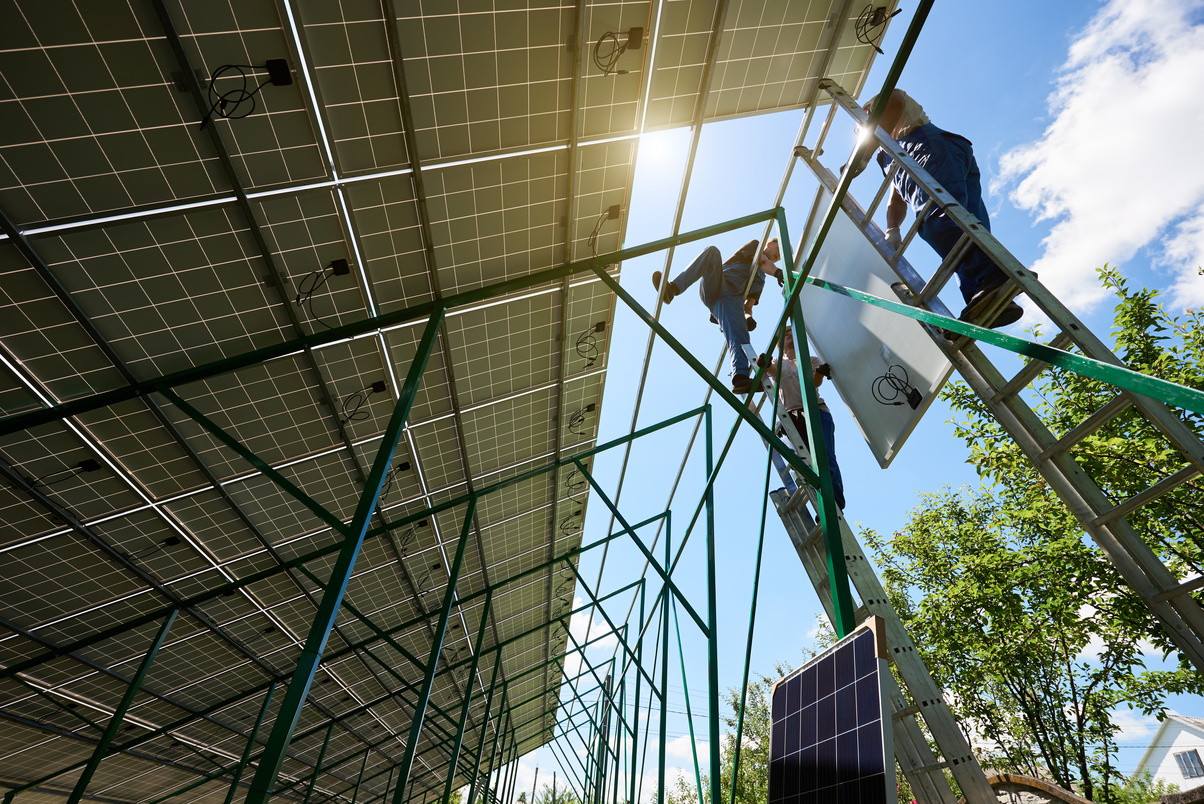 Mounters team installing solar batteries on house's roof.